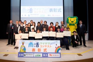 写真１　2019年1月19日、キッザニア東京で「雨活アイデアコンテスト2018」の表彰式を開催した。最優秀賞を受賞した小学生4名、中学生4名とその家族、総勢22名をご招待した。（写真提供：ライオン株式会社）