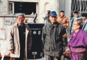 1995年1月に発生した阪神淡路大震災では、天水尊100基を運び込み、神戸市の市民に飲み水を入れる器として活用してもらった。左が徳永暢男さん。